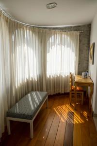 um quarto com uma cama, uma secretária e uma janela em La Coupole Hotel em Quito