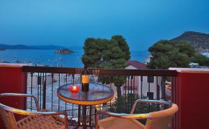 - une table avec une bouteille de vin sur le balcon dans l'établissement Epidavria Hotel, à Tolón