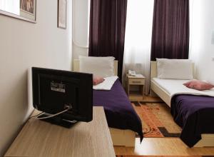 una camera con due letti e un monitor per computer su un tavolo di Garni Hotel Hamburg a Zaječar