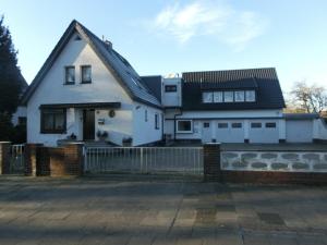 a white house with a fence in front of it at Sommer Gästehaus in Bremerhaven