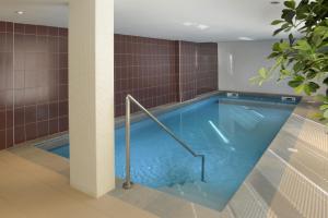 einen großen Pool im Bad mit einer Fliesenwand in der Unterkunft DOMITYS Le Parc de Saint-Cloud in Cambrai