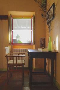 a dining room with a table and a chair and a window at Monte da Xica - Somente Adultos in Zambujeira do Mar +36 photos