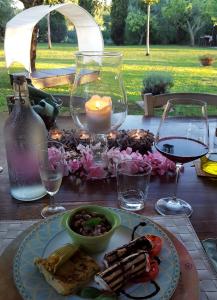 una mesa con un plato de comida y copas de vino en Casal di Peppe B&B, en Orentano