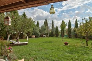 a woman laying in a hammock in a yard at Casal di Peppe B&B in Orentano