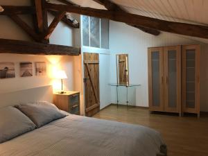 a bedroom with a bed and a table with a lamp at Les Vieilles Ombres in Bagnizeau