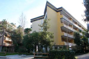 a yellow building with trees in front of it at Claudia 3 in Grado