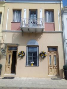 a building with a balcony and flowers on it at Arhontiko Pepos in Nafpaktos