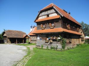 una gran casa de madera con un perro parado frente a ella en Tradicije Cigoc en Čigoč