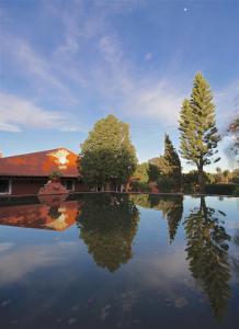 a house with a reflection in a pond at Monte da Xica - Somente Adultos in Zambujeira do Mar