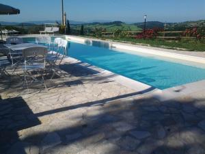 una piscina con mesa y sillas junto a ella en Borgo De Salaioli, en Scansano