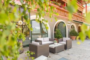 un patio avec des chaises et des tables à l'extérieur d'un bâtiment dans l'établissement Hotel Edelweiss, à Braies