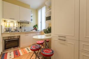 a kitchen with white cabinets and red stools at Ca' dei Nomboli Canal View in Venice