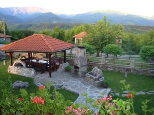 un jardin avec un kiosque et une table dans l'établissement Guest House Tsvetina, à Apriltsi