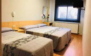Una habitación de hotel con dos camas y una ventana. en Hotel Viñas 17, en Teruel 17 fotos más