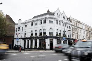 a white building on a city street with cars at Hand & Flower in London