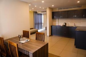 a kitchen and dining room with a wooden table and chairs at U C plaza in Perintalmanna