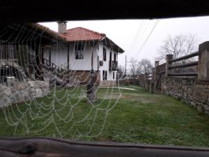 una cerca frente a una casa con un patio en Guest House Tsvetina, en Apriltsi