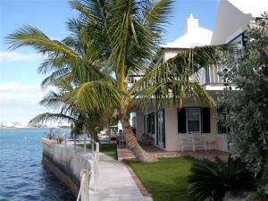 una casa con palmeras frente al agua en Watercolours en Mount Pleasant