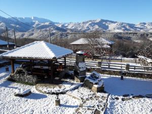 un pabellón cubierto de nieve con montañas al fondo en Guest House Tsvetina, en Apriltsi