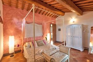 1 dormitorio con cama con dosel en una habitación en Appartamento in Casale toscano, en Orentano