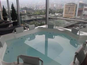 bañera de hidromasaje en una habitación con vistas a la ciudad en Hotel Sixtina Plaza Medellin, en Medellín