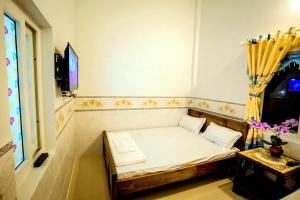 ein kleines Bett in einem Zimmer mit einem TV in der Unterkunft Motel Thuyền & Biển in Ly Son