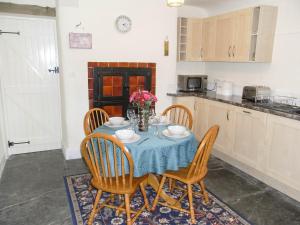 a kitchen with a table with a blue table cloth at Y Bwythyn at Henfaes in Rhydymain