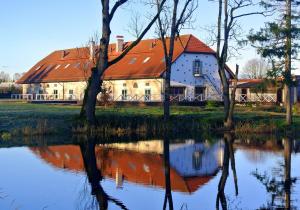 une maison avec un toit rouge à côté d'un lac dans l'établissement Üksik Rüütel Hotel, à Kurna