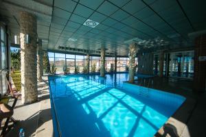 een groot zwembad met blauw water in een gebouw bij Hotel Fortuna in Banja Luka