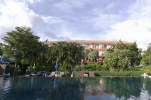 查汶的住宿－PTK公寓酒店，一座带椅子的游泳池以及一座建筑