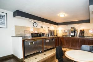 a kitchen with wooden cabinets and a clock on the wall at Super 8 by Wyndham Orlando International Drive in Orlando
