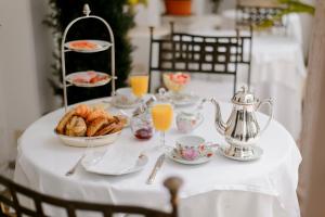 a table with a white table cloth with cups and plates of food at Hotel Opera in Munich
