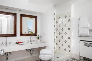 a white bathroom with two sinks and a shower at Hotel La Minerva in Capri