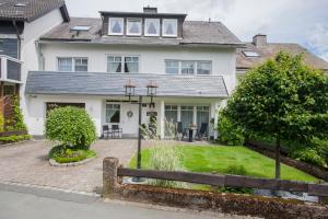 a white house with a fence in front of it at Hotel Forsthaus in Winterberg