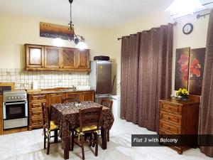 a kitchen with a table and a kitchen with a refrigerator at SEAFRONT I Pretty Bay Apartments in Birżebbuġa