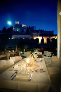 a table with wine glasses and a view of a castle at Locanda ai Capitelli in Soave