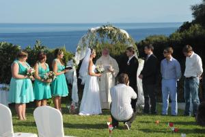 a bride and groom standing in front of a wedding ceremony at Mando Beachfront in Stafylos
