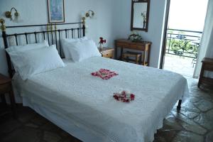 a bedroom with a white bed with flowers on it at Mando Beachfront in Stafylos