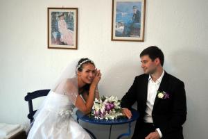a bride and groom sitting next to each other at Mando Beachfront in Stafylos