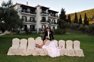 a bride and groom posing in front of chairs at Mando Beachfront in Stafylos