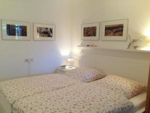 een slaapkamer met een bed en drie foto's aan de muur bij Haus Roland Wohnung 32 in Zinnowitz
