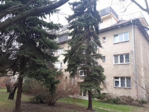 a large building with trees in front of it at Útulný apartmán v Bratislava 15 in Bratislava
