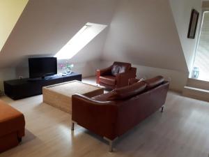 a living room with a couch and chairs and a tv at Útulný apartmán v Bratislava 15 in Bratislava
