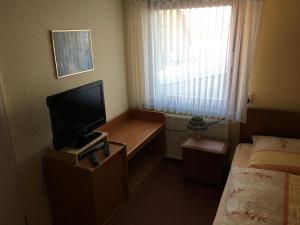 a small room with a television and a bed at Landgasthaus Hoffmeister in Hehlen