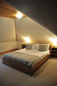 a bedroom with a large bed with two lamps at The Old Coach House, Alltshellach Cottages in North Ballachulish