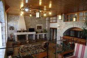 a large living room with a fireplace and a stone wall at Mani Hotel in Areopoli