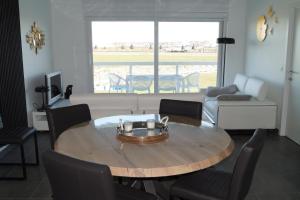 a living room with a table and a couch at Villa Jalina Sailors Beach in Nieuwpoort
