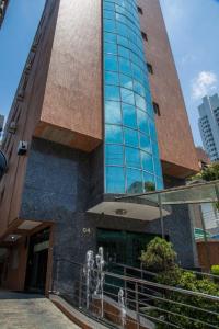 een hoog gebouw met twee standbeelden ervoor bij Atlantico Inn Apart Hotel in Santos