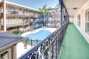 an apartment balcony with a pool in a courtyard at LA Plaza Apartments in Metairie