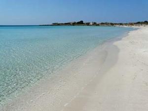 einen Strand mit weißem Sand und blauem Wasser in der Unterkunft SAMARCANDA camere e appartamenti in Porto Cesareo